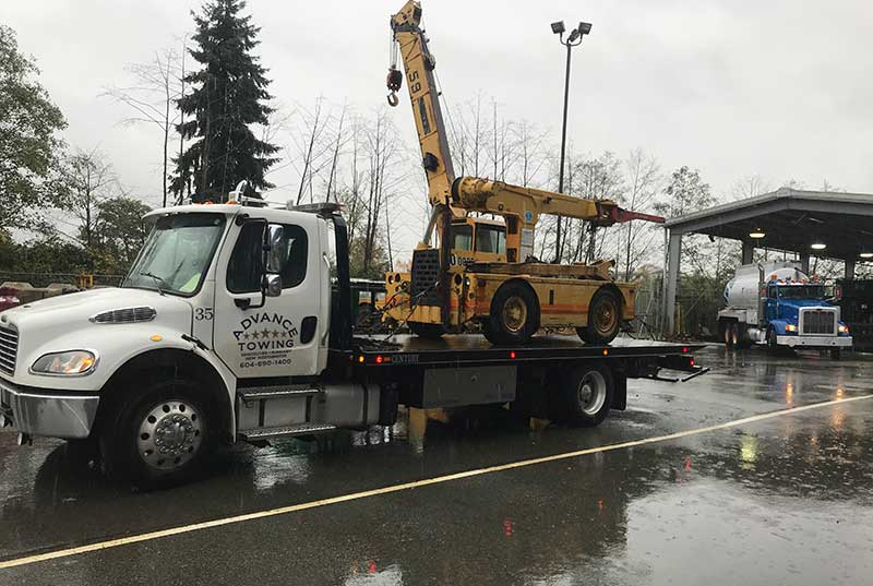 A tow truck with a crane on it for Advanced auto towing services